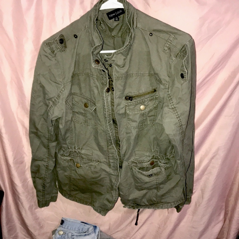 Green sweater.Has multiple zippers and pockets with buttons.Scrunched up in back